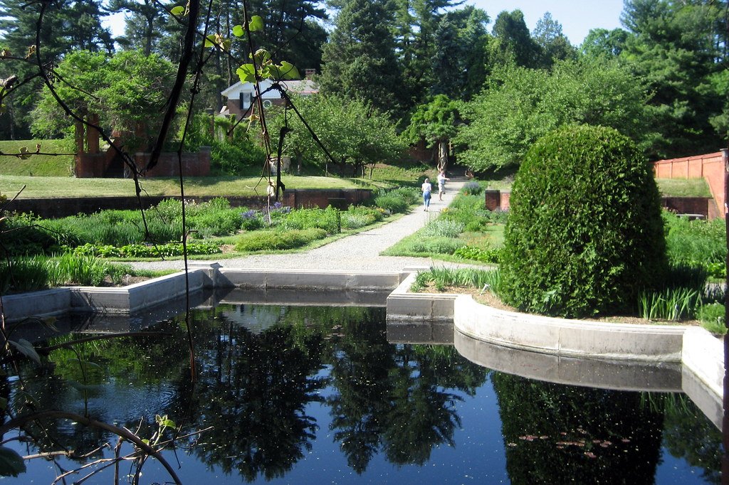 Traditioneller Bauerngarten mit Blumen, Gemüse und Wegkreuz
